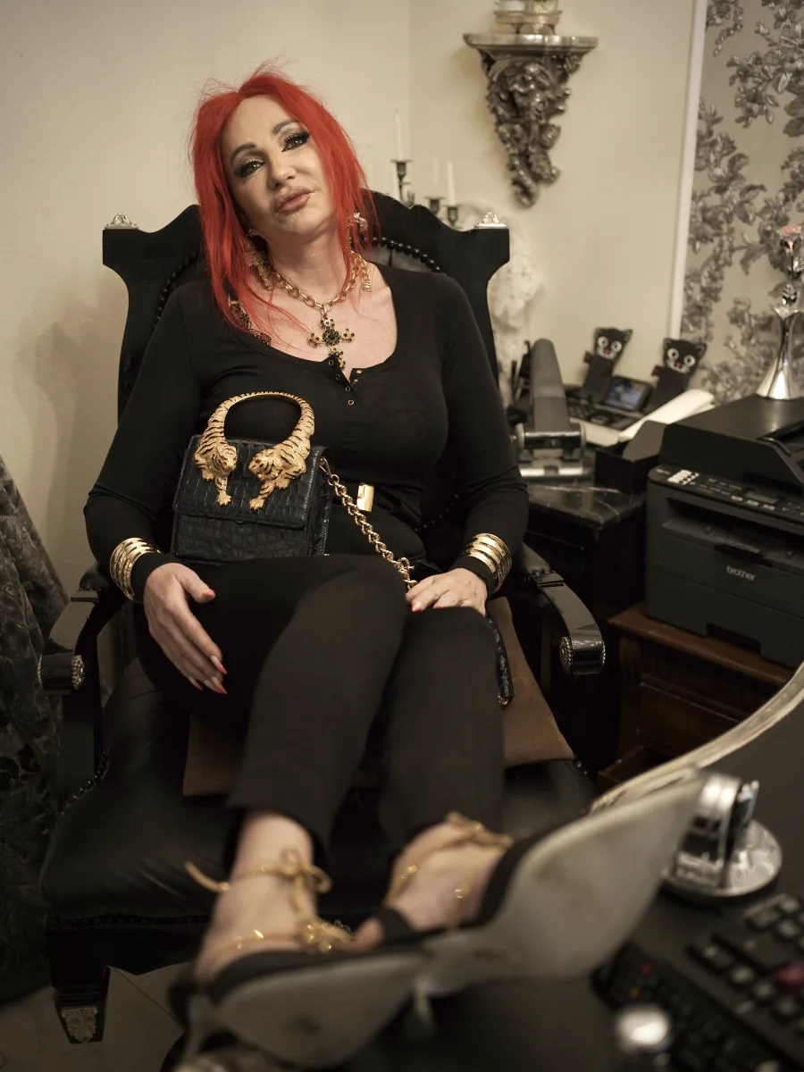 Michaela Hoppe im schwarzen Outfit mit goldener Roberto Cavalli Roar Bag und eleganten Schuhen