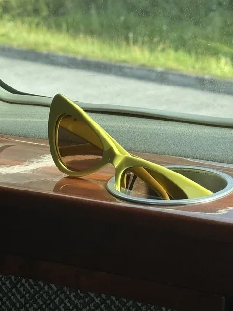 Gelbe Sonnenbrille liegt am Fenster