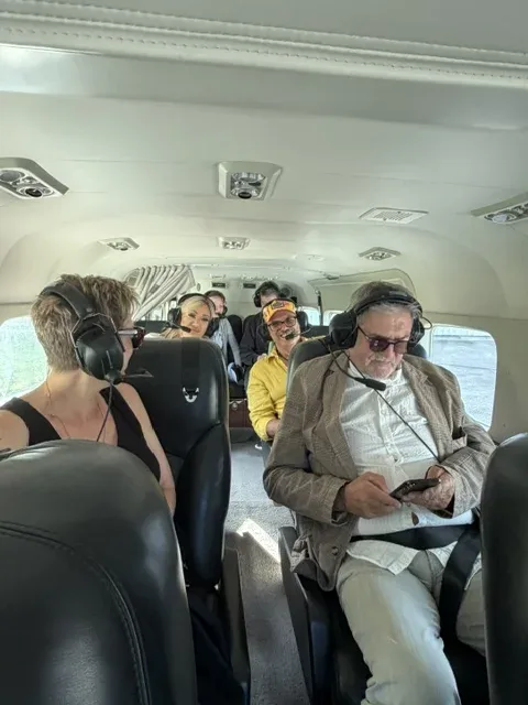 Mehrere Familienmitglieder sitzen mit Headsets im Flugzeug