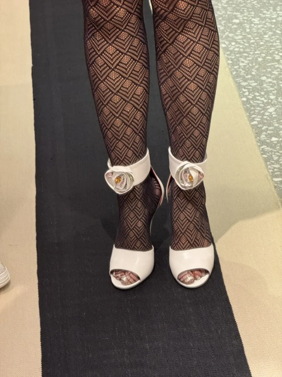 Gemusterte schwarze Strumpfhose in weißen Peeptoe-Sandaletten