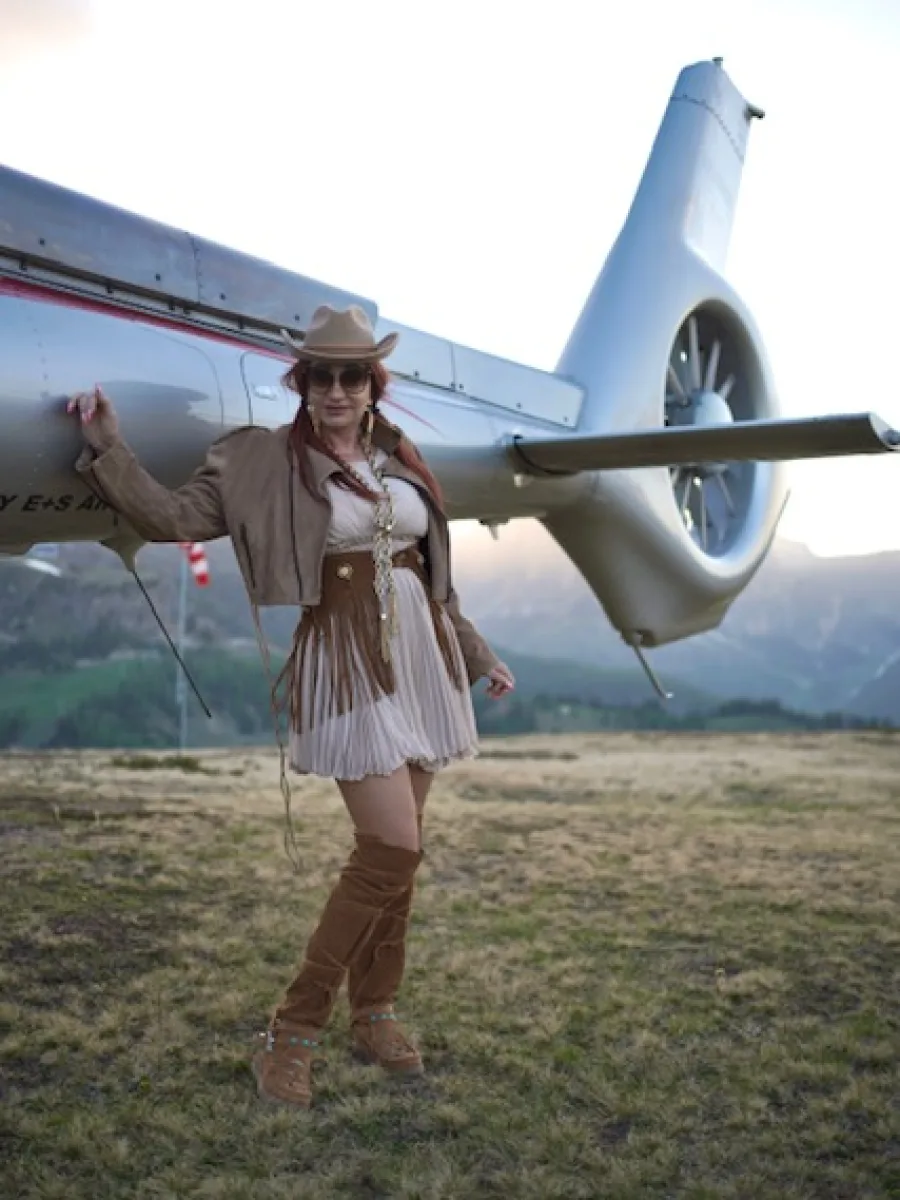 Michaela im Western-Outfit seitlich vor einem Helikopter
