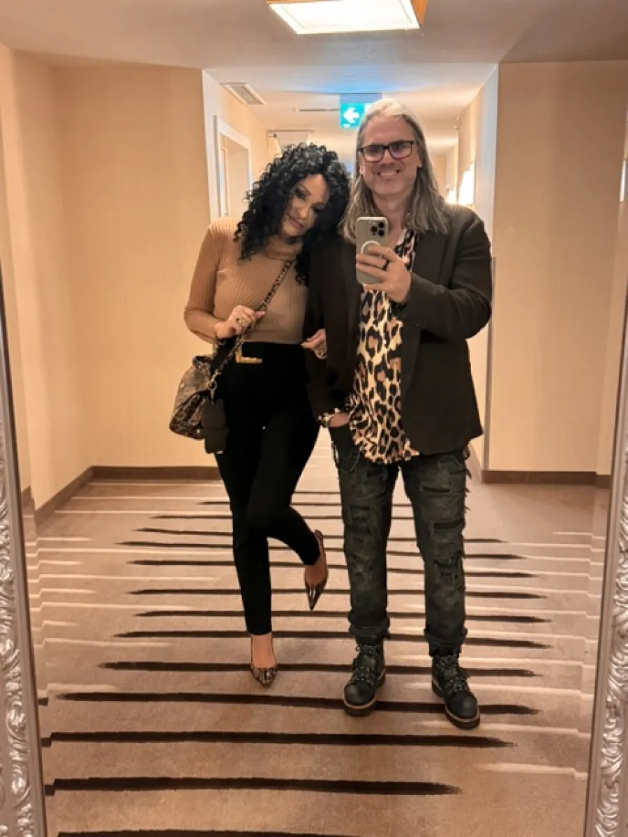 Michaela und Silvio Hoppe in einem Hotelflur mit abgestimmten dunklen Looks