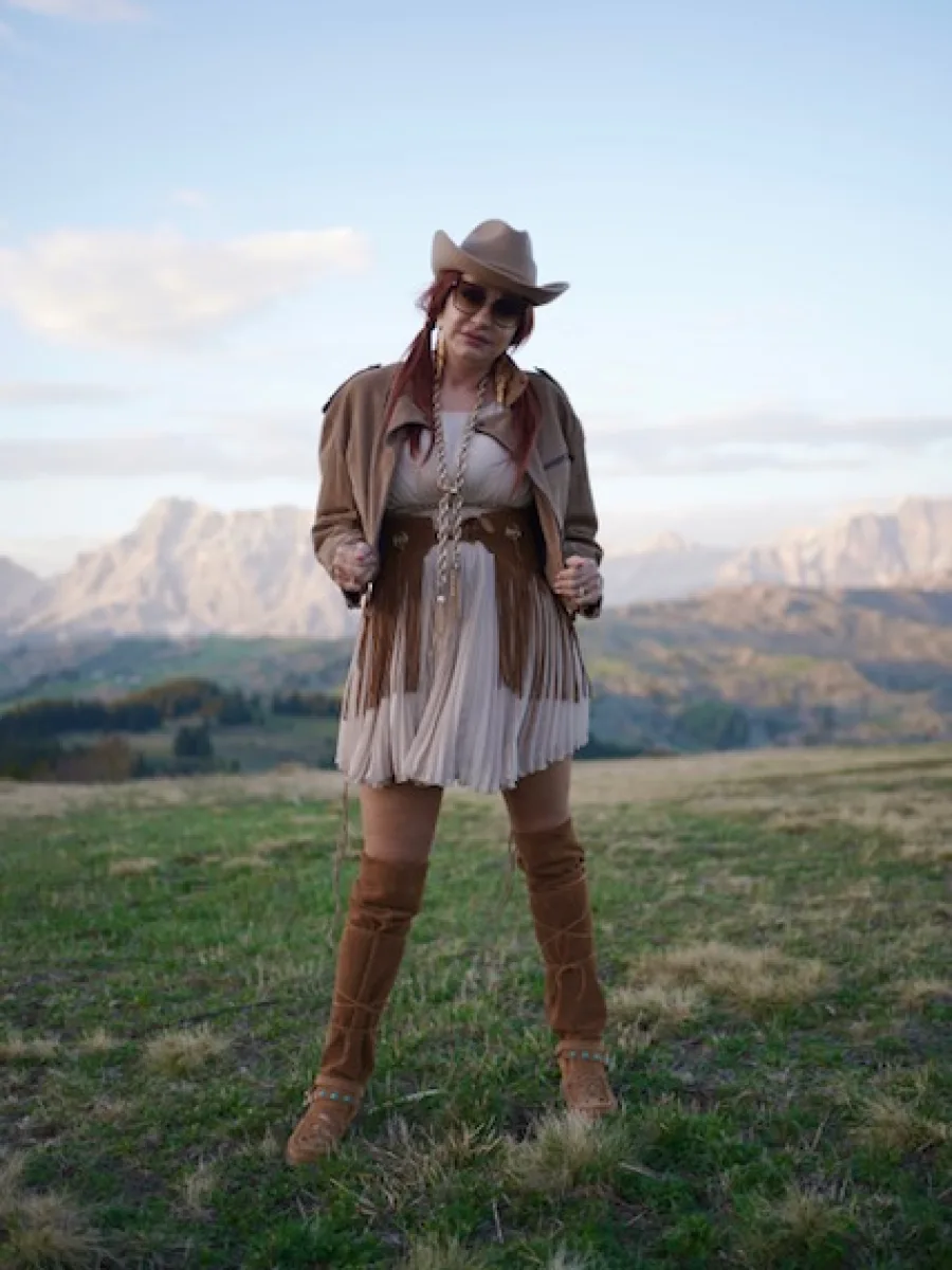 Michaela im vollständigen El-Vaquero-Outfit vor einer Bergkulisse