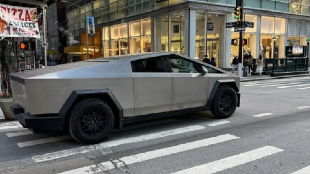 Eine New Yorker Einkaufsstraße mit Geschäften und einem futuristischen Fahrzeug
