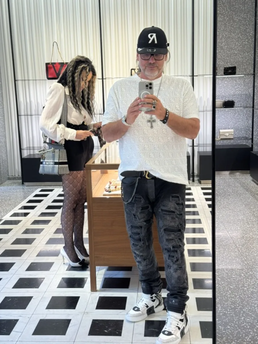 Silvio fotografiert sich im Spiegel, während Michi sich in einer Boutique umsieht