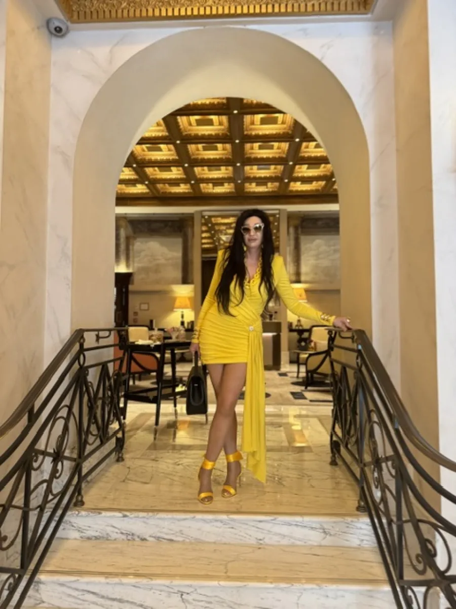 Michaela Hoppe in gelbem Kleid mit feiner Strumpfhose und gelben offenen Sandaletten