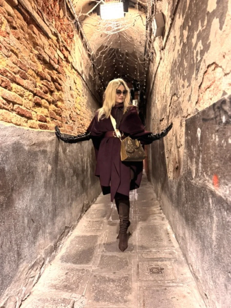Michi mit blondem Haar in einer schmalen Gasse