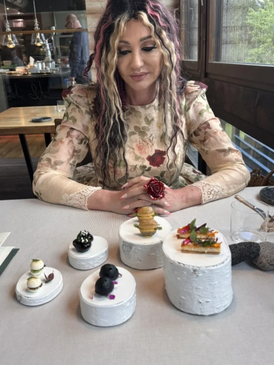 Michi sitzt im geblümten Kleid am gedeckten Tisch im Terra – The Magic Place